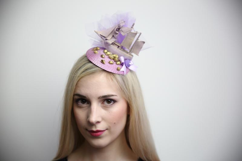 IMAGE - Lilac fascinator with medium sized model shop, painted lilac with gold details. Purple tulle, bow and gold seashells. Fixes to hair with a comb