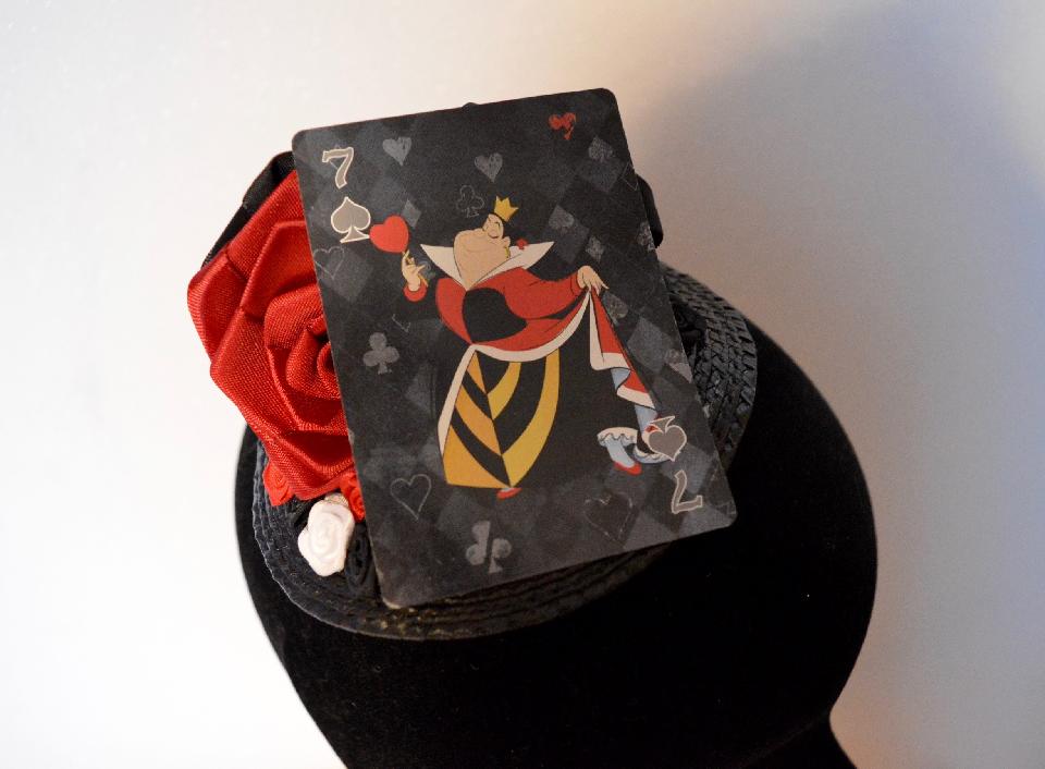 IMAGE - Black straw fascinator with red, white and black ribbon roses and playing card featuring the Queen of Hearts. Fixes to hair with a comb.