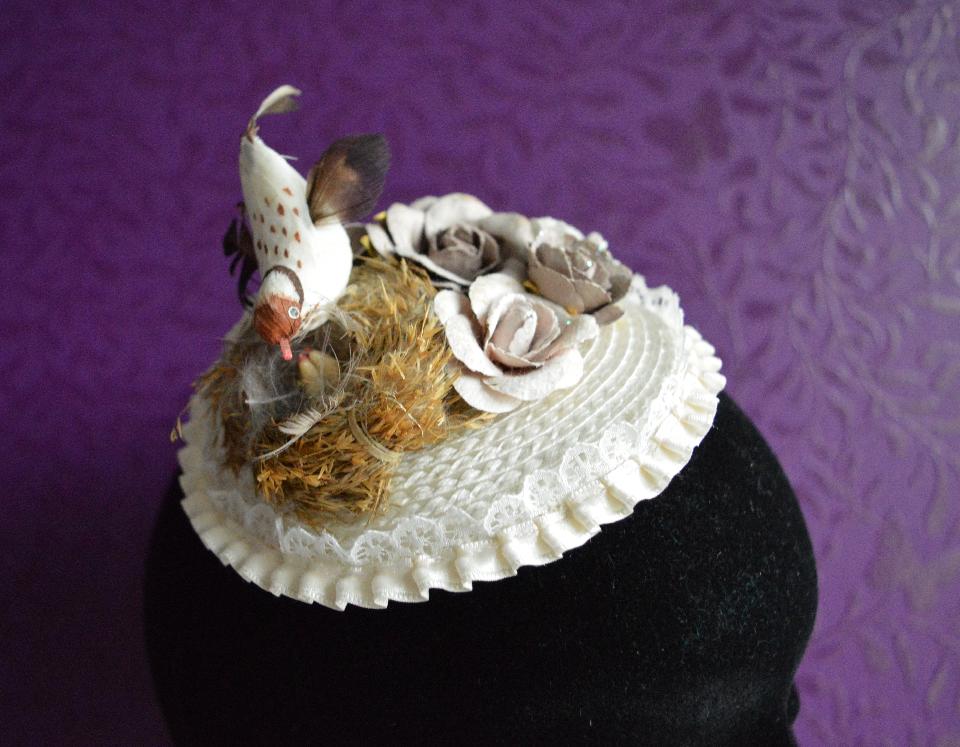 IMAGE - Off-white fascinator with lace border. Decorated with bird and paper flowers. The flowers are very sturdy but should not get wet. Fixes to hair with a comb.
